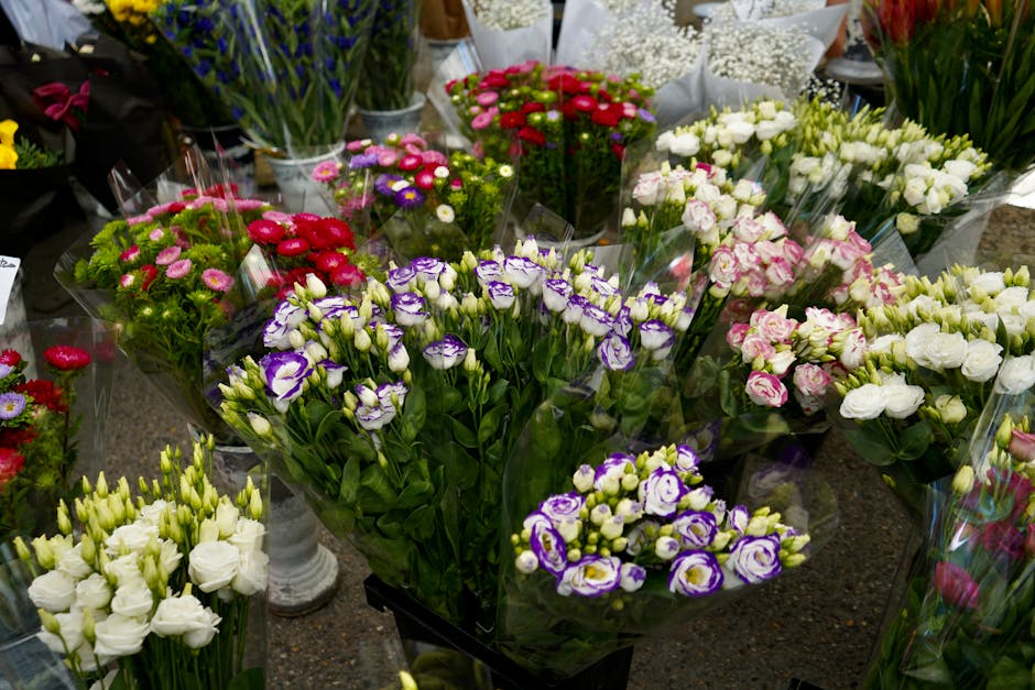 A vibrant display of fresh flowers arranged in bouquets at Flowers Upper Clapton, featuring a variety of blossoms including purple and white eustoma, pink and white roses, and red and pink daisies, al