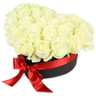 Tailored for heartfelt occasions in Upper Clapton, this sumptuous heart-shaped floral gift box overflows with gleaming white roses-some tightly budded, others gracefully expanding, their creamy petals edged with the faintest tint of pale green. Each bloom is painstakingly positioned within a deep, matte black hatbox, creating a harmony of volume and texture that translates Upper Clapton's artistic flair into a visual poem. The luxurious presence of a bold scarlet red satin ribbon, tied on the front in a fluid, classic bow with soft, flowing ends, introduces passion and a celebratory accent, echoing beloved local traditions along the borders of Springfield Park and Overbury Street. Set underneath steady, bright light that enhances the velvet softness of each petal and brings out the ribbon's sheen, the arrangement sits sharply against a brilliant white background, giving the flowers centre stage. Like whispers of love on a breezy day near the River Lea, this creation is intended for romantic gestures, meaningful anniversaries, or as a dignified symbol of enduring friendship. Each aspect-from flower selection to ribbon's final flourish-reflects the thoughtfulness and care that define Flowers Upper Clapton's work and the unique spirit of this North London community.