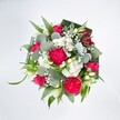 A vivid, top-down view of a lush, circular bouquet shows a joyful mix of hot pink and pure white flowers resting on a bright white background, as if laid out on a clean studio table in Upper Clapton. At the heart of the design, large, ruffled hot pink carnations unfurl in generous layers, their frilled petals creating soft shadows and a sense of volume that feels almost touchable. Between them, deep pink to fuchsia roses nestle closely, some fully open with elegant spiralled centres, others still in bud, promising more colour to come. Scattered throughout are clusters of tiny white spray chrysanthemums and other daisy-like blooms, forming little cushions of texture that lighten the entire composition. Wisps of white baby's breath thread delicately through the bouquet, adding an airy, cloud-like softness that softens the strong pink tones. Slender ivory buds, likely alstroemeria or lily-like flowers, peek upwards and outwards, bringing a hint of refined elegance and gentle movement. Surrounding all of this, the greenery feels abundant and carefully planned: silvery-green eucalyptus leaves with their rounded, slightly waxy surfaces sit alongside long, bright green blades of foliage that arc gracefully. Darker, broader leaves-arranged in folded, collar-like shapes-frame the bouquet, giving it a polished outline that a florist in a local Upper Clapton workshop might prepare for a special delivery near Springfield Park or along Clapton Common. The lighting is even and clear, making each detail crisp, and the overall mood is celebratory yet tender, like a bouquet chosen to say I'm proud of you or You are loved, perfect for birthdays, promotions, or cheering up a grey London afternoon.